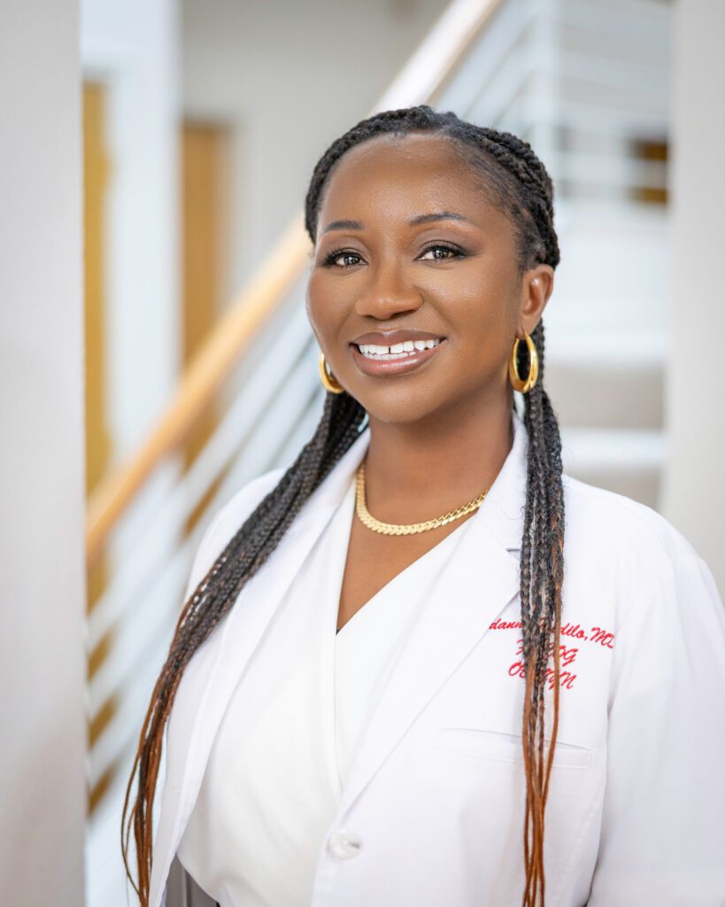 Smiling woman in a white lab coat.